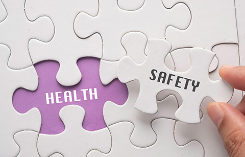 a puzzle piece with safety on it about to be set over an area with health written on it